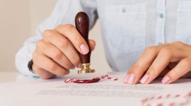 person-using-wax-seal-blurred-certificate (1)